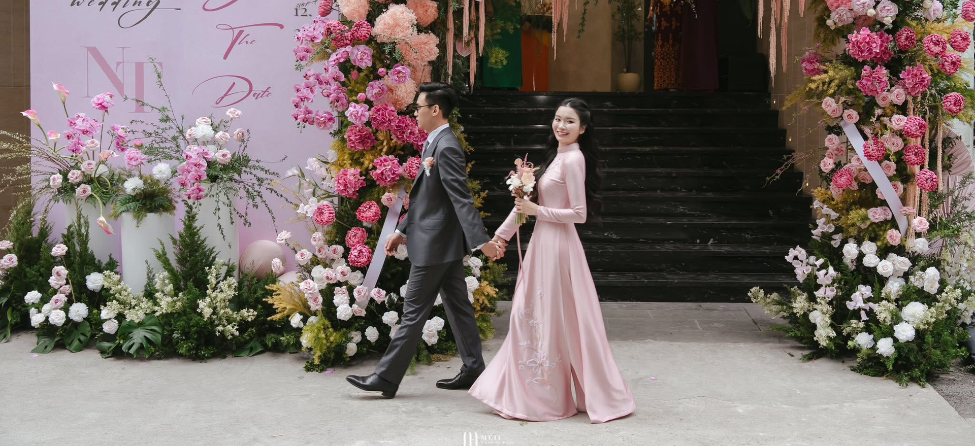 Cô dâu chú rể bên cổng hoa trong lễ cưới ngoài trời