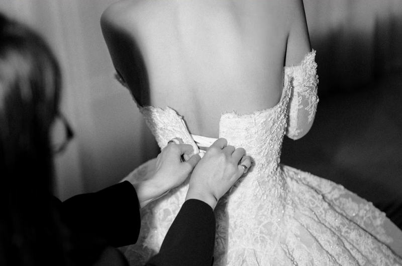 Đôi tay chỉnh dây corset váy cưới trong ảnh đen trắng