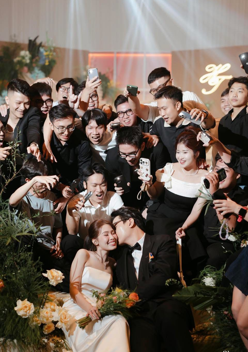 Cặp đôi hôn nhau giữa những người bạn đang vui mừng trong tiệc cưới