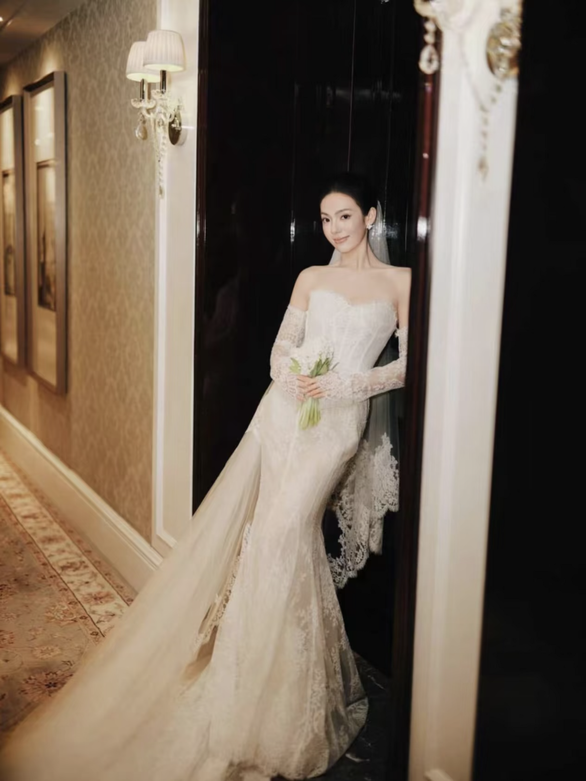 Cô dâu cầm bó hoa trong váy ren tại khung cửa