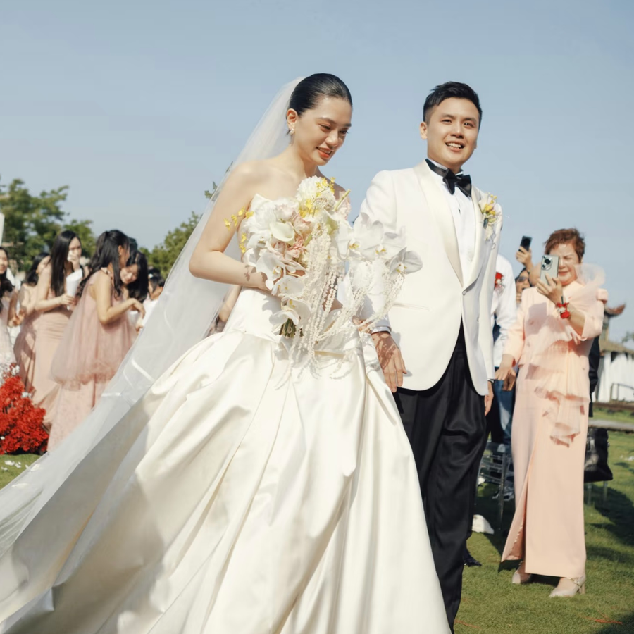 Cặp đôi bước đi giữa quan khách trong lễ cưới ngoài trời